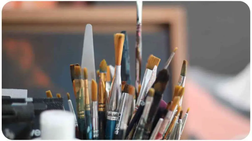 many paint brushes are sitting on top of a table