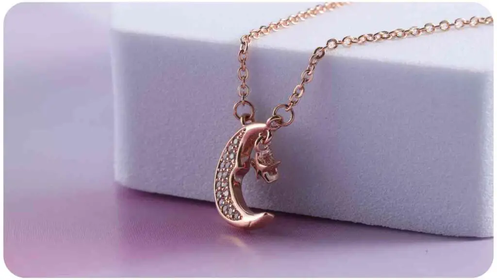 a rose gold necklace with the letter c on it