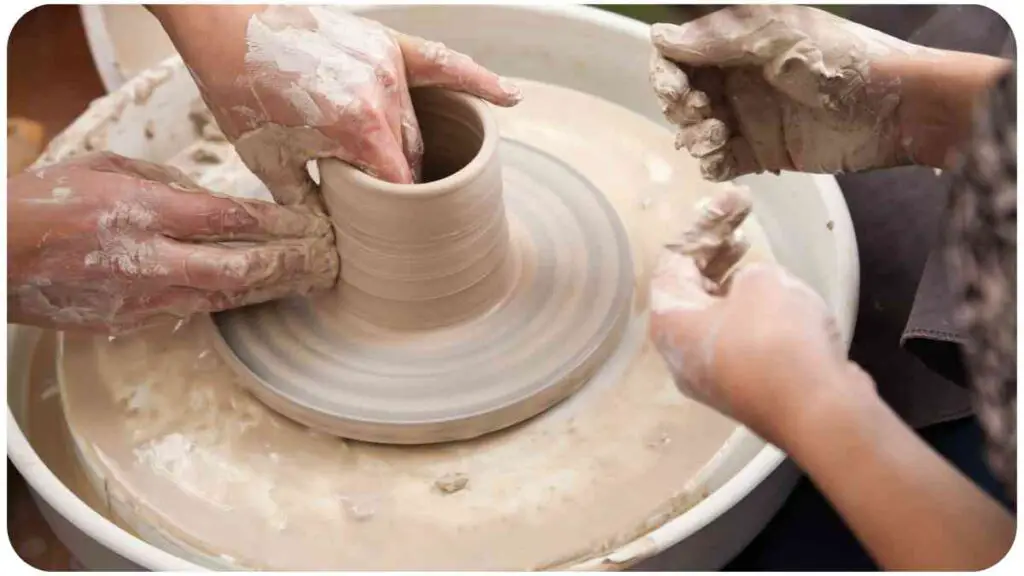 a group of people are making a pot on a potter's wheel.