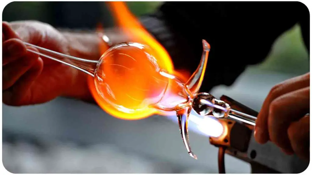 a person is blowing glass with a flame on it