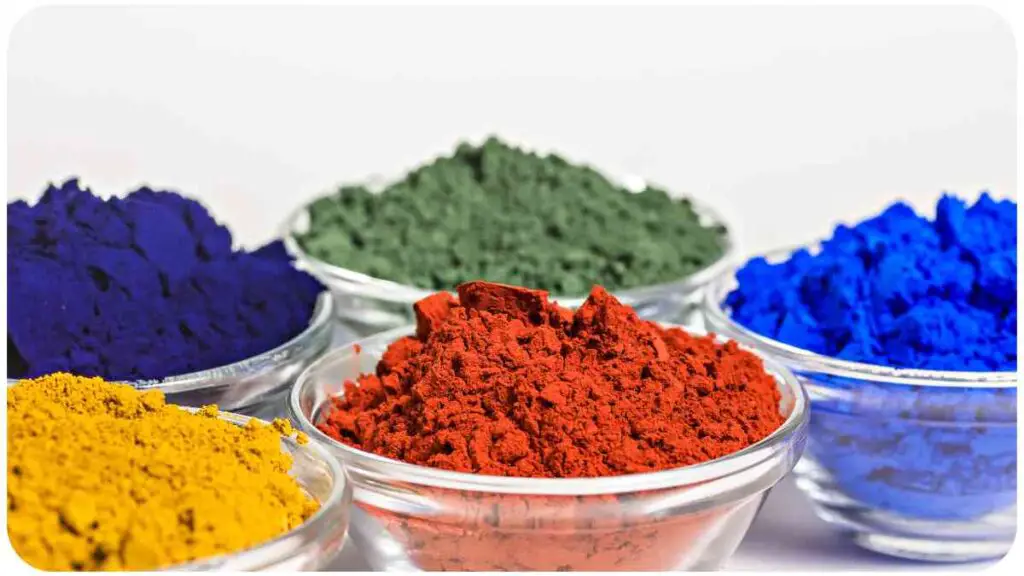 {several different colored powders in bowls on a white surface}