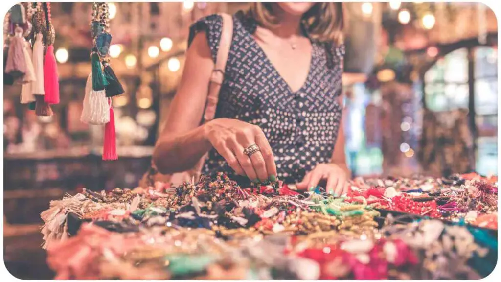 a person standing in front of a table full of necklaces