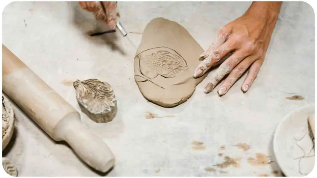 the hands are working with clay on a table