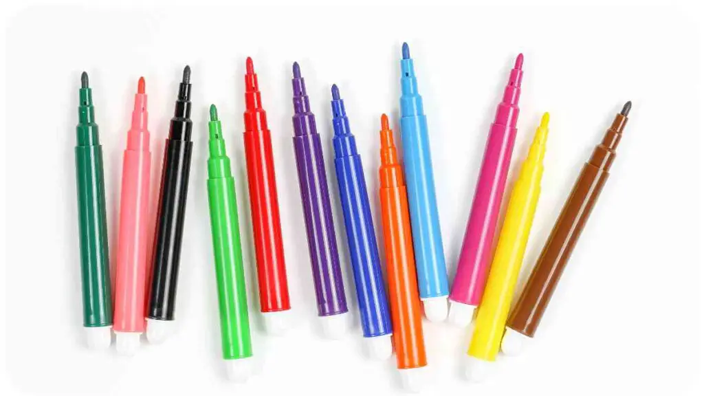 several different colored markers on a white surface